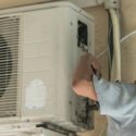 HVAC technician repairing an air conditioning unit, illustrating essential maintenance for residential systems in Willis, TX.