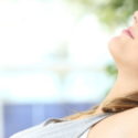 Woman relaxing indoors, emphasizing clean air and comfort, relevant to HVAC maintenance and air quality discussions.