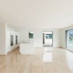 Minimalist kitchen interior with large windows, showcasing bright natural light and clean design for HVAC maintenance advice.