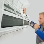 Technician servicing wall-mounted air conditioning unit with tools for Easco HVAC maintenance.