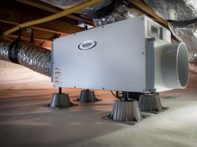 Air system unit in dimly lit crawl space with metal ducting, showcasing HVAC solutions by Easco Air Conditioning.