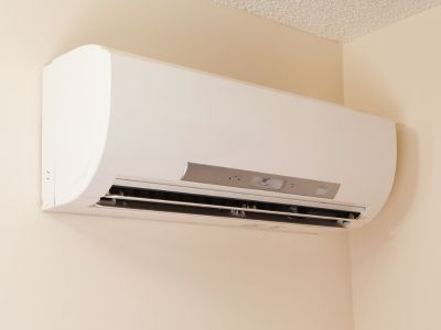 Ductless mini-split air conditioning unit mounted on a wall, illustrating modern cooling technology for enhanced indoor comfort and energy efficiency.
